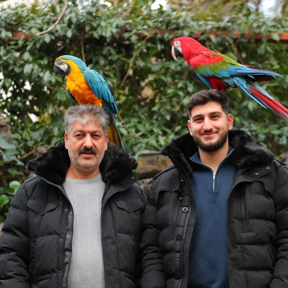 Simar und sein Vater mit Papageien – das familiäre Team hinter dem Gartenbauunternehmen