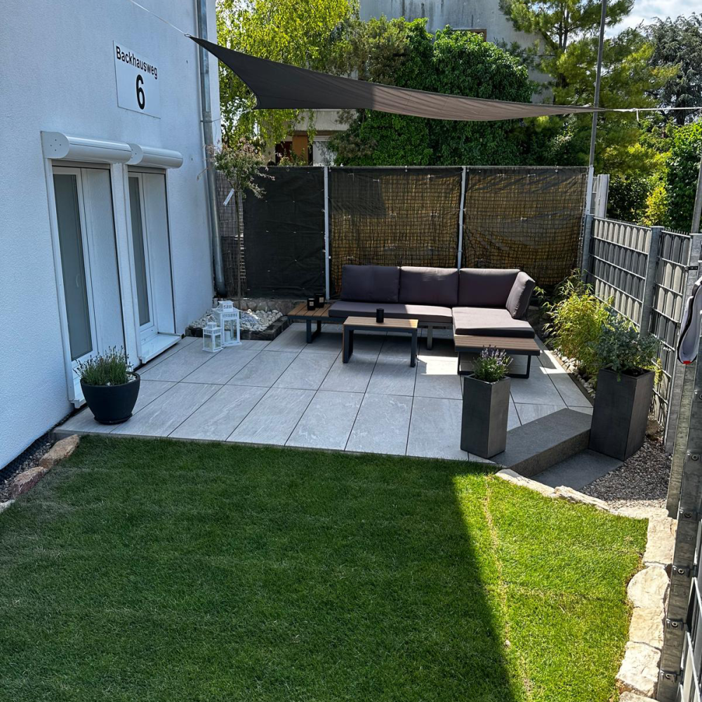 Moderne Terrasse mit neuer Rasenfläche und großformatigen Terrassenplatten in Mannheim